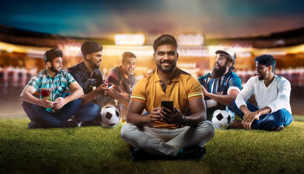 Group of Indian cricket fans checking scores together at a stadium